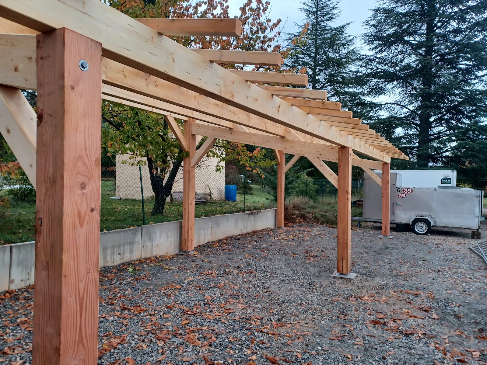 Longue structure en bois dans une cour arborée